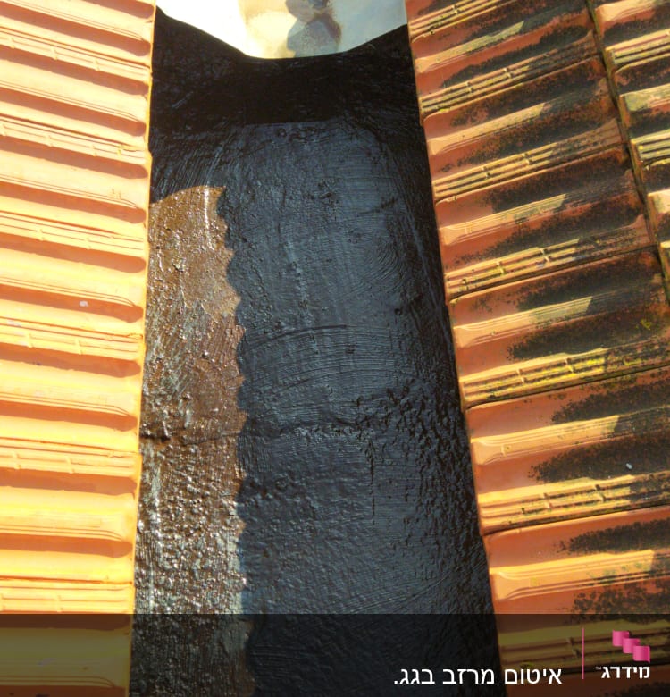 איטום גג עם זפת בין רעפים כתומים